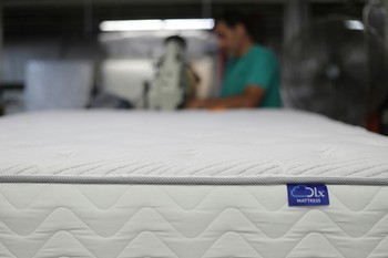 a man is working on a mattress in a warehouse a man is working on a mattress in a warehouse